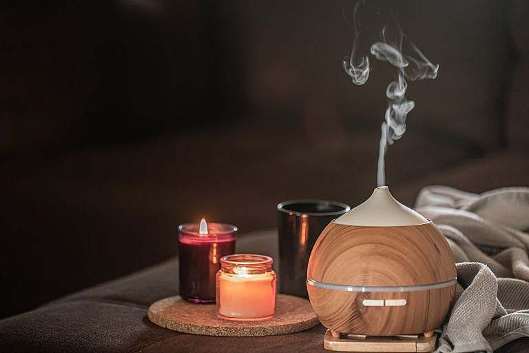 Aromatherapy 1 oil diffuser blurred space near burning candles aromatherapy health care concept